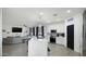 Open-concept kitchen with island seating, stainless appliances, white cabinetry, and a view into the living area at 6818 W St Catherine Ave, Laveen, AZ 85339