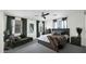 Comfortable main bedroom with a king bed, chaise lounge, accent wall, and three windows with natural light at 6818 W St Catherine Ave, Laveen, AZ 85339