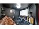 Modern theater room with a projector screen, large leather sofa, bean bag chairs, and a popcorn machine at 6818 W St Catherine Ave, Laveen, AZ 85339