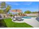 This backyard features a pool, hot tub, lounge chairs, patio umbrella, and a manicured lawn at 7242 E Tyndall St, Mesa, AZ 85207