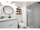 Clean bathroom with white vanity, round mirror, and glass-enclosed shower, blending style and functionality at 7242 E Tyndall St, Mesa, AZ 85207