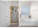 Bright bathroom with glass block window, soaking tub, and a separate glass-enclosed shower at 7242 E Tyndall St, Mesa, AZ 85207