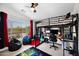 Well-lit bedroom featuring a loft bed, desk area, beanbag chairs, and a large window with neighborhood views at 7242 E Tyndall St, Mesa, AZ 85207