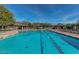 Stunning community pool featuring lounge chairs, covered seating, and mature trees at 7242 E Tyndall St, Mesa, AZ 85207