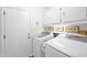 Functional laundry room with modern washer and dryer, ample storage, and clean design, making laundry tasks easier at 7242 E Tyndall St, Mesa, AZ 85207