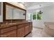 Bathroom features a double vanity with granite counters, a large mirror, and stylish chandelier at 7250 E Paradise Dr, Scottsdale, AZ 85260