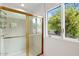 Bathroom with a glass-enclosed shower, window, and leafy outdoor view, offering a refreshing experience at 7250 E Paradise Dr, Scottsdale, AZ 85260