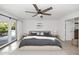 Bedroom with ceiling fan, neutral walls, with a large sliding glass door and tile flooring at 7250 E Paradise Dr, Scottsdale, AZ 85260