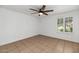 A blank bedroom with a ceiling fan and a window with shutters is ready for you to move in at 7250 E Paradise Dr, Scottsdale, AZ 85260