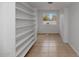 Spacious walk-in closet with tiled floor and custom shelving offering ample storage and organization at 7250 E Paradise Dr, Scottsdale, AZ 85260