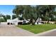 Spacious white home featuring a three-car garage and mature trees in the front yard at 7250 E Paradise Dr, Scottsdale, AZ 85260