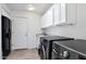 Well-lit laundry room with washer, dryer, sink, and white cabinets at 7250 E Paradise Dr, Scottsdale, AZ 85260