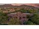 Expansive residence with elegant architectural details, nestled among trees with mountain views in the background at 7445 E Eagle Crest Dr # 1122, Mesa, AZ 85207