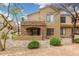Inviting tan stucco home featuring a stone-accented balcony and covered outdoor space with neutral desert landscaping at 7445 E Eagle Crest Dr # 1122, Mesa, AZ 85207