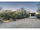 Desert home at dusk featuring a bridge leading to a garage, with thoughtful landscape lighting at 8644 E Sweetwater Ave, Scottsdale, AZ 85260