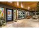 Well-lit covered patio with stone flooring and wood ceiling showcasing a seamless indoor/outdoor living space at 8644 E Sweetwater Ave, Scottsdale, AZ 85260