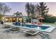 Scenic view of a backyard pool with lush landscaping and a covered patio area at 8644 E Sweetwater Ave, Scottsdale, AZ 85260
