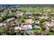 Aerial view captures a home with a pool, tennis court, mature trees, and a nearby golf course at 87 Biltmore Est, Phoenix, AZ 85016