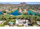 Panoramic aerial shot of a Scottsdale community showcasing beautiful houses and lake with mountain views in the background at 87 Biltmore Est, Phoenix, AZ 85016