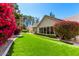 Lush backyard with artificial lawn, surrounded by trees and flowering bushes, with a view of the home at 87 Biltmore Est, Phoenix, AZ 85016