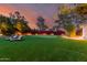 Beautiful backyard featuring a putting green, lounge chairs, and lush landscaping under a colorful sky at 87 Biltmore Est, Phoenix, AZ 85016