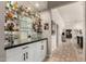 Stylish bar area with glass shelving, cabinetry, and adjacent hallway at 87 Biltmore Est, Phoenix, AZ 85016