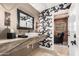 Modern powder room featuring a vessel sink, stone countertop, and bold floral wallpaper at 87 Biltmore Est, Phoenix, AZ 85016