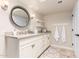 This bathroom features a white vanity, a round mirror, neutral decor, and towel hooks at 87 Biltmore Est, Phoenix, AZ 85016