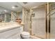 Bright bathroom featuring gold accents and a tiled shower with a glass door at 87 Biltmore Est, Phoenix, AZ 85016