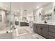 This bathroom features a zero-entry shower, dual vanities, expansive countertops, and neutral decor at 87 Biltmore Est, Phoenix, AZ 85016