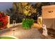 Well-maintained exterior with mature trees, manicured shrubs, and decorative garden statues, creating a peaceful setting at 87 Biltmore Est, Phoenix, AZ 85016