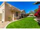 Manicured backyard with synthetic lawn, flowing to a gazebo with table and chairs and home's exterior at 87 Biltmore Est, Phoenix, AZ 85016