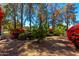 Gravel front yard with landscaped beds of flowers and mature shade trees at 87 Biltmore Est, Phoenix, AZ 85016