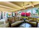 Comfortable seating inside lanai with view of blooming backyard shrubs at 87 Biltmore Est, Phoenix, AZ 85016