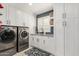 Well-organized laundry room featuring modern appliances, white cabinetry, and stylish backsplash at 87 Biltmore Est, Phoenix, AZ 85016
