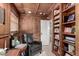 Cozy home office nook with wood paneling, coffered ceiling, built-in shelving, and comfortable leather chair at 87 Biltmore Est, Phoenix, AZ 85016