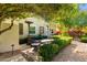 Comfortable outdoor seating area with heaters, complemented by manicured hedges, trees, and flowering bushes at 87 Biltmore Est, Phoenix, AZ 85016