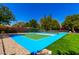 Outdoor pickleball court with blue and green surface, surrounded by lush greenery and trees at 87 Biltmore Est, Phoenix, AZ 85016