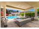Inviting pool area featuring a spa, covered patio with seating, and lush landscaping at 87 Biltmore Est, Phoenix, AZ 85016
