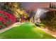 Beautifully landscaped yard with manicured lawn, vibrant red flowers, and pathways leading to the house at 87 Biltmore Est, Phoenix, AZ 85016