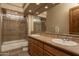 Bathroom with dual sinks, tiled floor, tiled shower with glass door, and neutral colored walls at 8925 E Ann Way, Scottsdale, AZ 85260