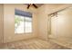 Neutral bedroom featuring a ceiling fan, a large window with light-blocking blinds, and a mirror sliding door closet at 8925 E Ann Way, Scottsdale, AZ 85260