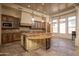 Open kitchen with custom cabinetry, large island, stainless steel appliances, and travertine flooring at 8925 E Ann Way, Scottsdale, AZ 85260