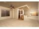 Spacious living room with carpet, neutral walls, bar with granite counters, and a wine cellar behind a glass door at 8925 E Ann Way, Scottsdale, AZ 85260