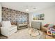 Charming Bedroom with a crib, rocker, decorative wallpaper, and a changing table at 9052 N 29Th St, Phoenix, AZ 85028