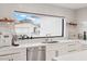 Bright kitchen featuring a window overlooking backyard, white cabinets, stainless steel appliances, and modern finishes at 9052 N 29Th St, Phoenix, AZ 85028