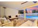 Inviting covered patio with brick flooring overlooks a sparkling pool and manicured backyard at 9052 N 29Th St, Phoenix, AZ 85028
