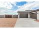 Home exterior showcasing a three-car garage and a paved driveway, complemented by desert landscaping for easy maintenance at 9430 W Sandstone Mountain Dr, Casa Grande, AZ 85194