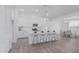 Bright kitchen featuring modern island with bar stool seating, stainless steel appliances, and white cabinetry at 9430 W Sandstone Mountain Dr, Casa Grande, AZ 85194