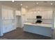 Contemporary kitchen with stainless steel appliances, white cabinetry, and an expansive central island at 9430 W Sandstone Mountain Dr, Casa Grande, AZ 85194